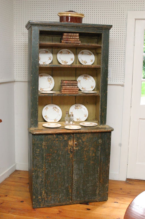 Yellow, green and blue! This sweet Canadian step back cupboard has seen many coats of paint in it's long lifetime. Its diminutive size is just charming. Three of the four shelves on the top have plate rails for display. The bottom has a two door